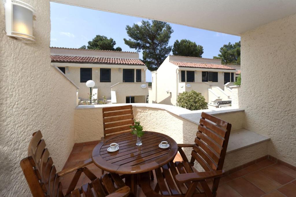 a wooden table and chairs on a balcony at Apartments Bellevue Plava Laguna in Poreč