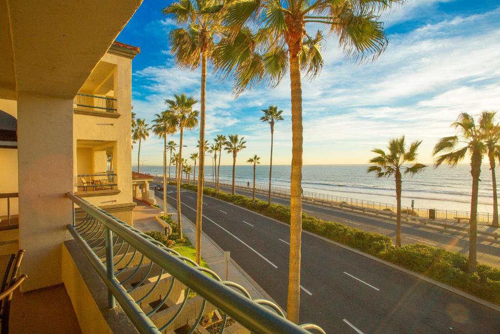 a balcony with palm trees and a road and the ocean at Tamarack Beach Hotel in Carlsbad
