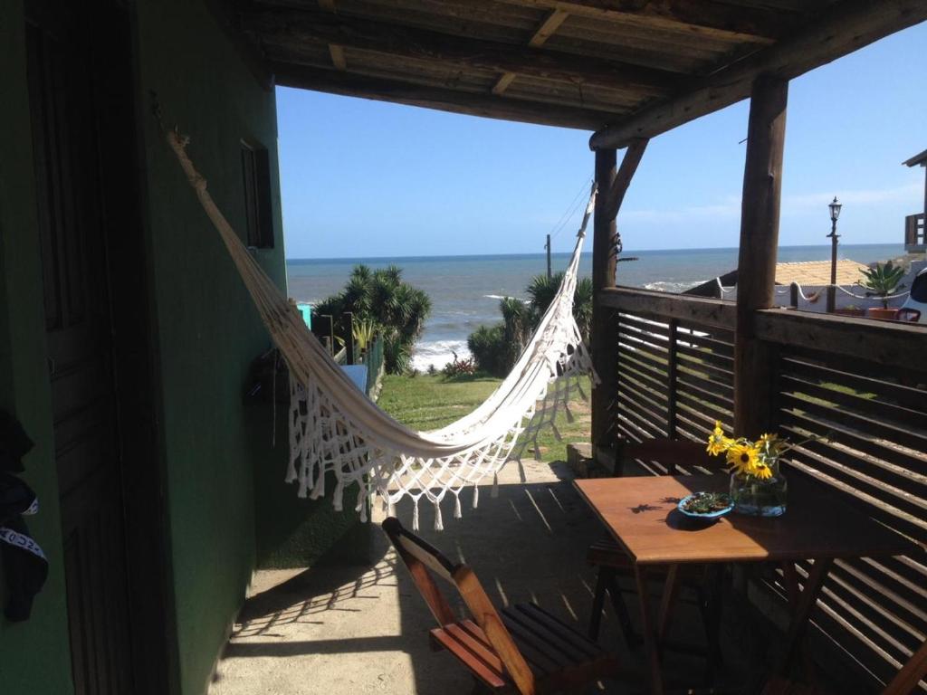 a hammock on the porch of a house overlooking the beach at Casa verde in Laguna