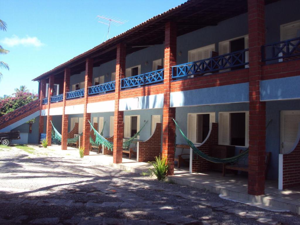 a building with hammocks on the side of it at Pousada Angra do Porto in Porto De Galinhas