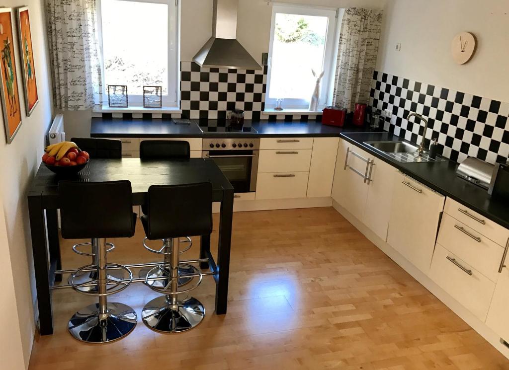 uma cozinha com uma mesa e azulejos pretos e brancos em TOP 601 Lothringen house em Bad Gastein