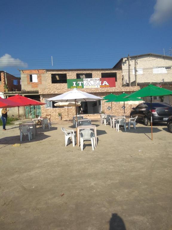 a group of tables and umbrellas in a parking lot at Pousada Itália in Guarujá