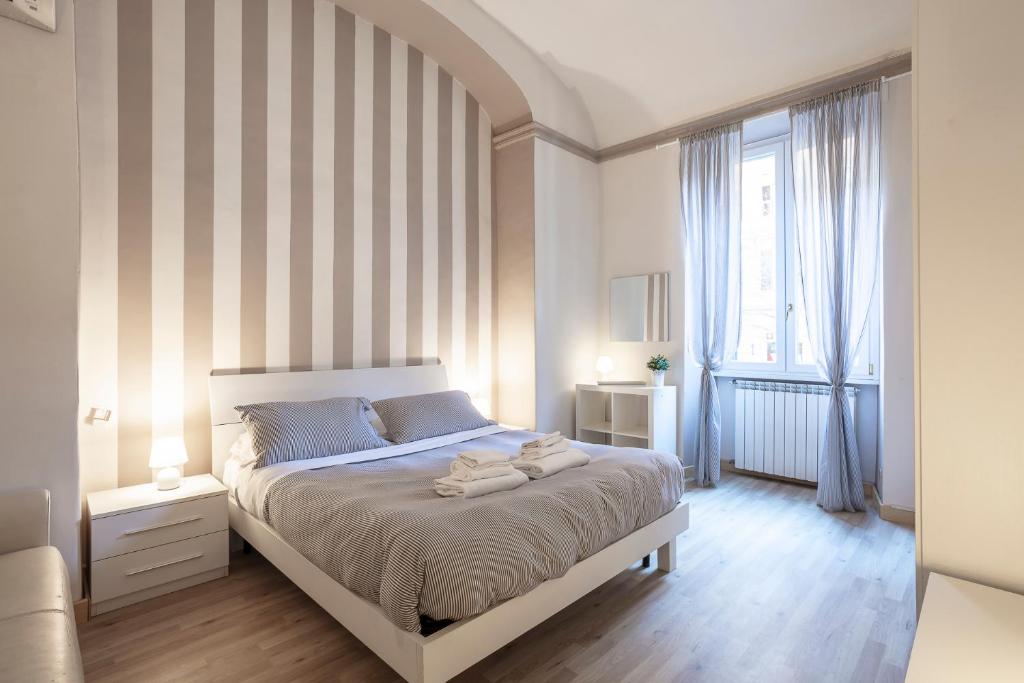 ローマにあるLiberty Houseのベッドルーム1室(ストライプの壁の大型ベッド1台付)