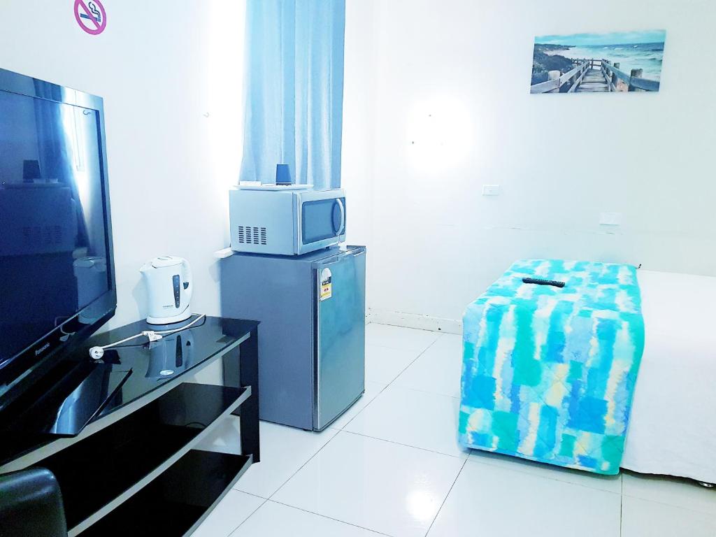 a living room with a bed and a tv at Perth City Motel in Perth