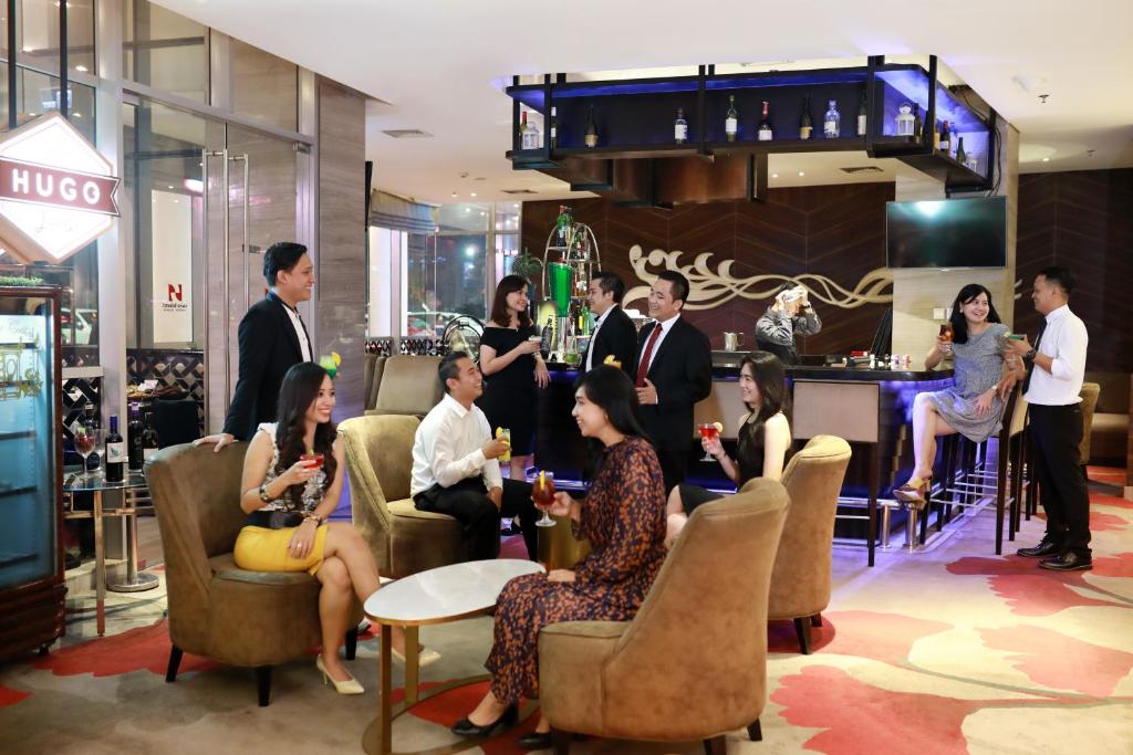 a group of people sitting in chairs in a lobby at Swiss-Belhotel Airport Jakarta in Tangerang