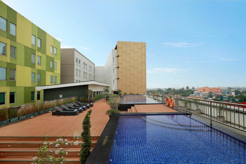 a building with a swimming pool on top of a building at Swiss-Belhotel Airport Jakarta in Tangerang