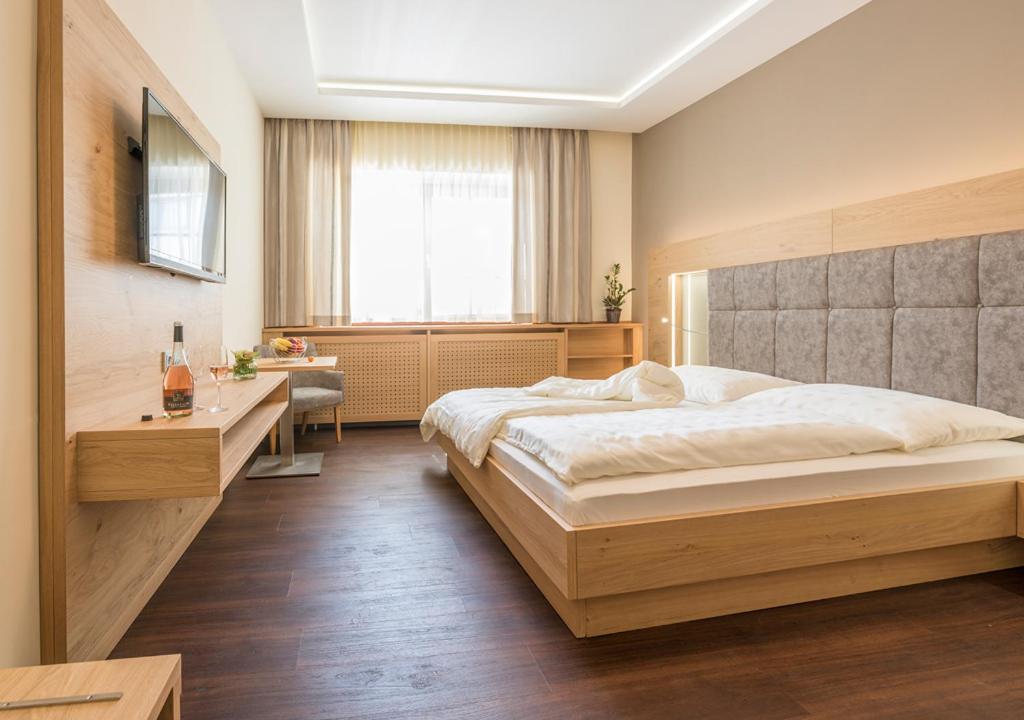 a bedroom with a large bed and a desk at Weingut Breitenfelder in Retz