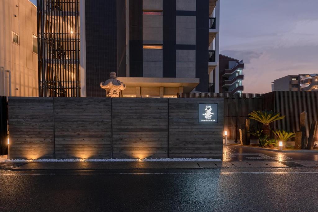 Un uomo in piedi sopra un edificio con le luci di Zen Kyoto Apartment Hotel a Kyoto