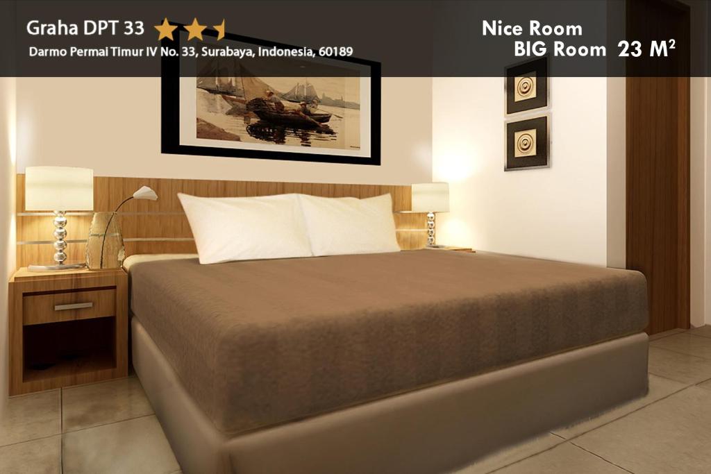 1 dormitorio con 1 cama y una foto en la pared en Hotel Graha DPT 33, en Surabaya