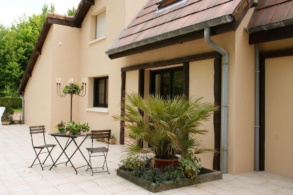 un patio con mesa y sillas junto a un edificio en La Villa Antalya, en Ault