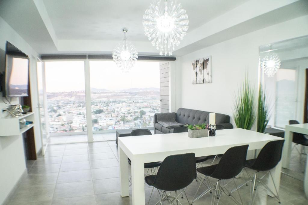 a dining room with a white table and chairs at Luxurious Condo & unparalleled Comfort inTijuana in Tijuana
