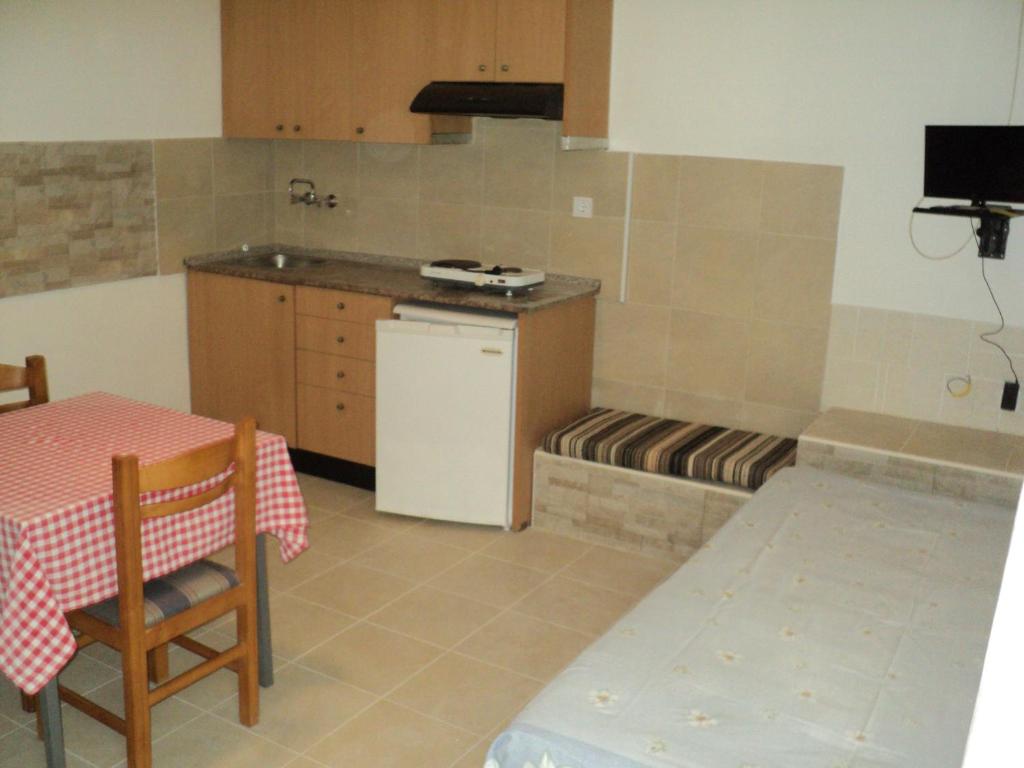 eine Küche mit einem Tisch und einem Tisch sowie eine Küche mit einem Herd in der Unterkunft Katerina Apartments in Kokkíni Khánion