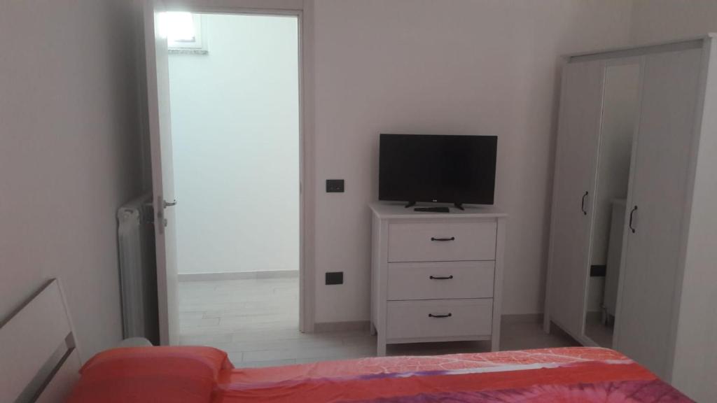 1 dormitorio con TV y vestidor con cama en Casa Vacanze Mercolino, en Bracigliano