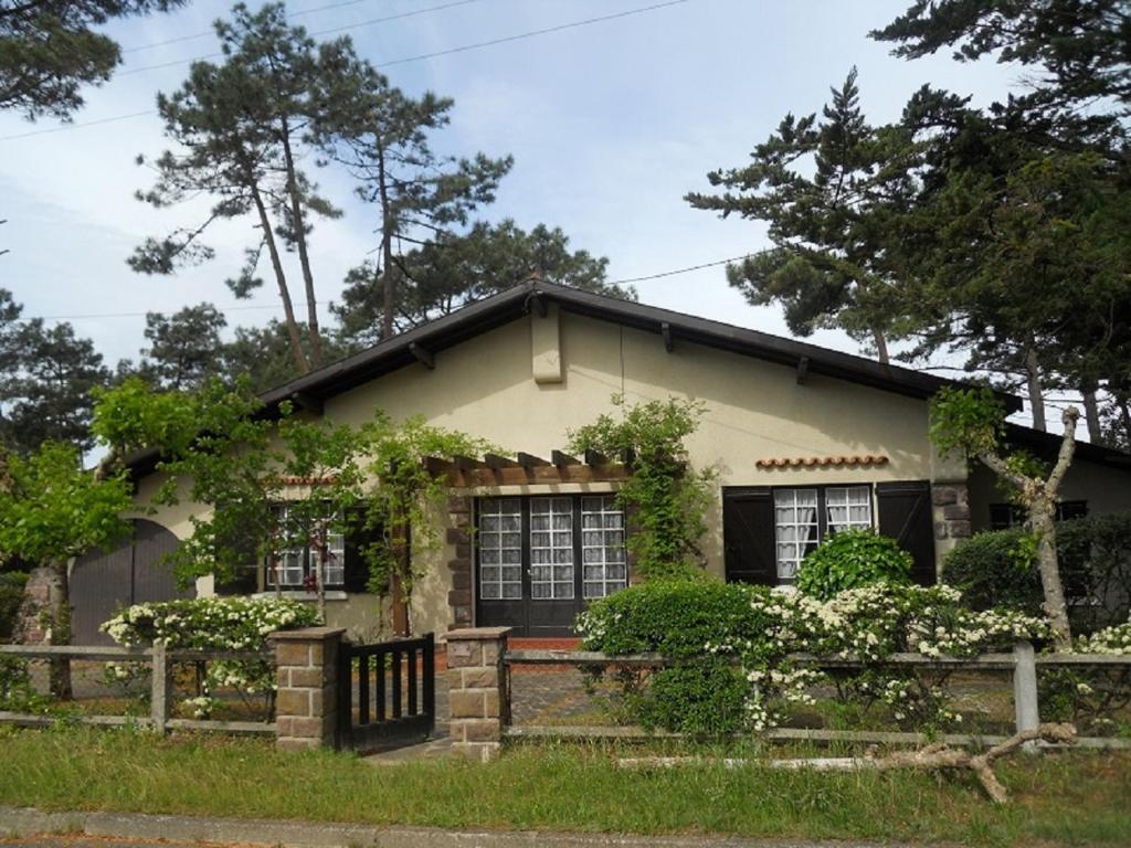 a house with a fence in front of it at La palombe in Mimizan-Plage