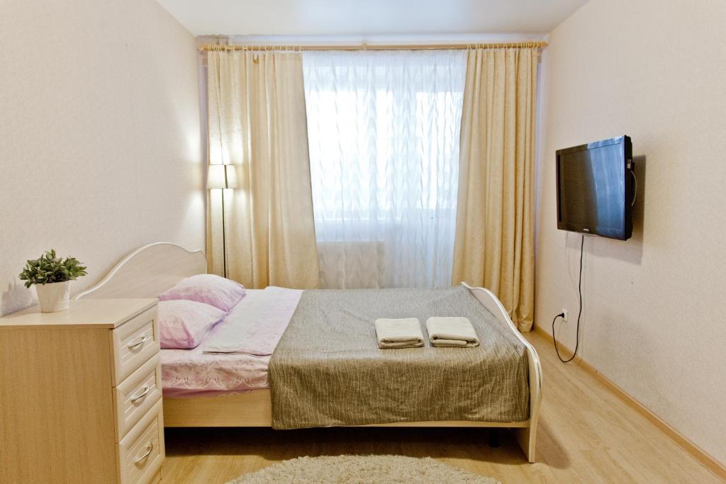 イジェフスクにあるApartments Severny, 54-8のベッドルーム1室(ベッド1台、タオル2枚付)