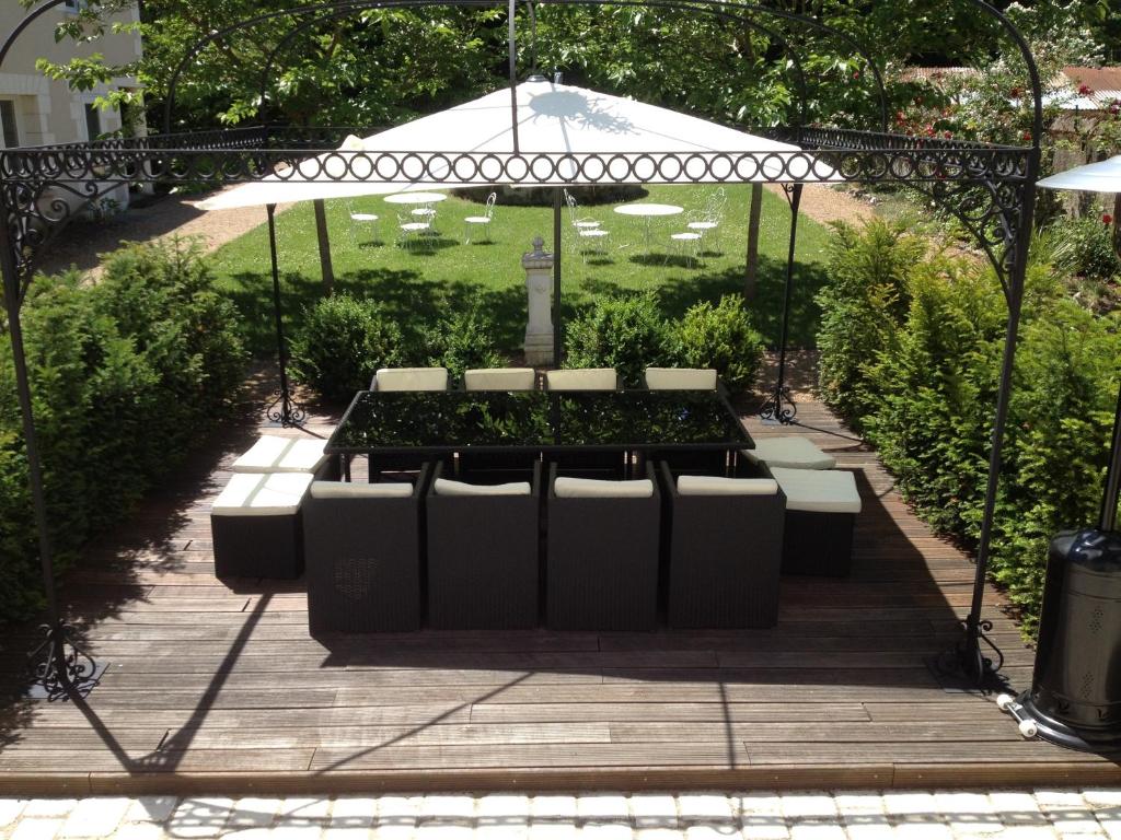 a garden with a table with plants and an umbrella at Manoir Du Parc (Adults only) in Amboise