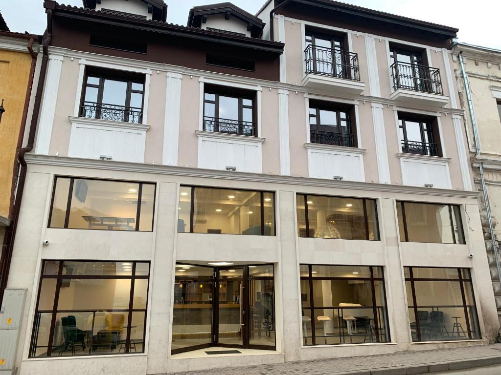 um grande edifício branco com janelas de vidro em ARTE Hotel rooms & apartments em Veliko Tŭrnovo