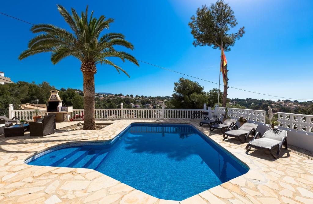 een zwembad op een patio met 2 palmbomen bij Villa Ritter - three bedroom with private pool - by Holiday Rentals Villamar in Benissa