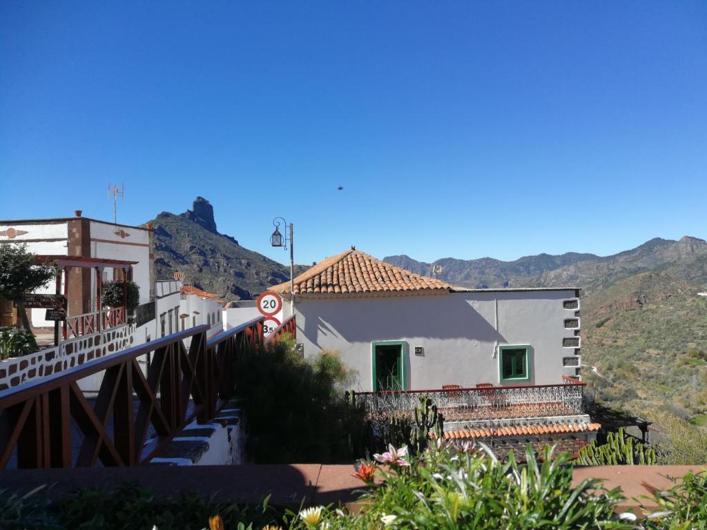 a house with a bridge and mountains in the background at Casa Servando in Tejeda