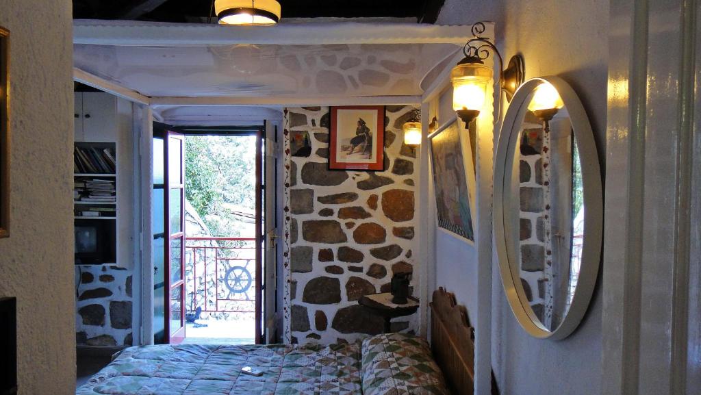 a bedroom with a bed and a stone wall at Tramontana in Hydra