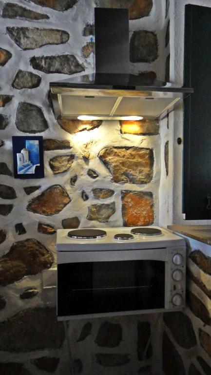 a stone wall with an oven in a kitchen at Tramontana in Hydra