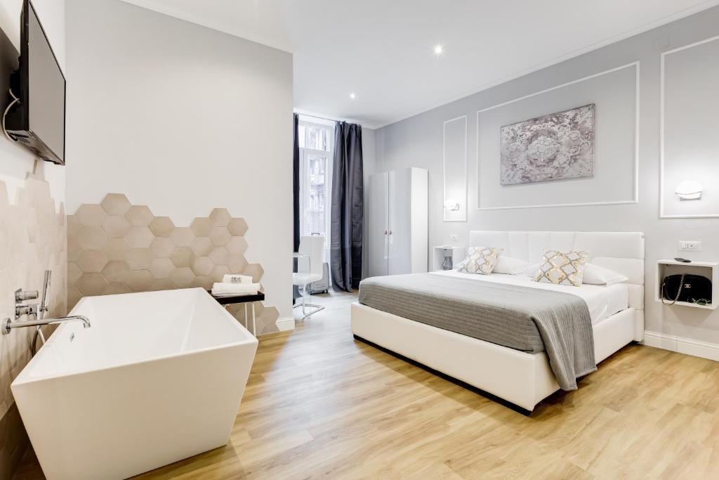 Habitación blanca con cama y bañera en Opera Private Suites by Premium Suites Collection, en Roma