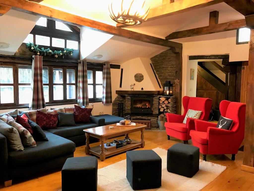 a living room with a couch and chairs and a fireplace at Chalet Jora - Total Chalets in Bansko