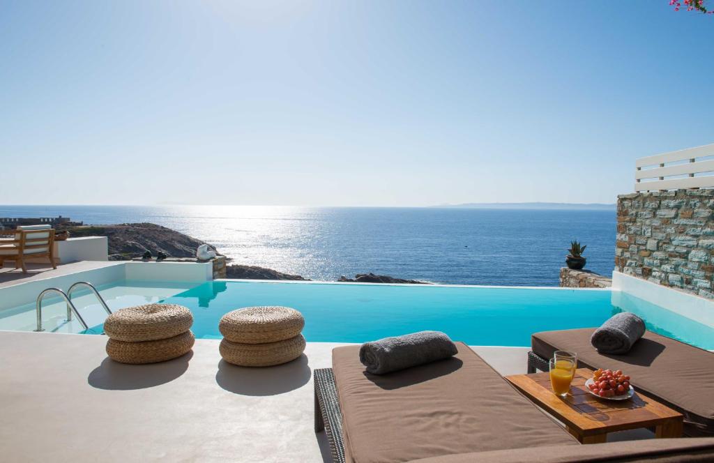 a pool with two beds and a view of the ocean at Villa Yalita in Melissaki