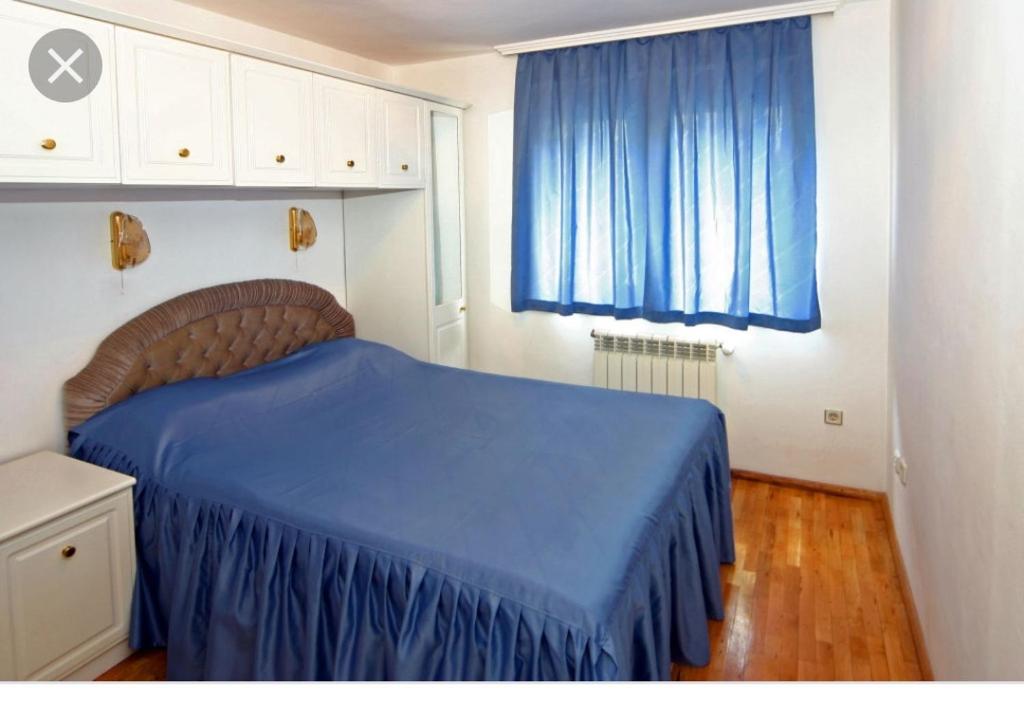 Apartment Pier في مدينة فارنا: غرفة نوم بسرير ازرق وستارة زرقاء