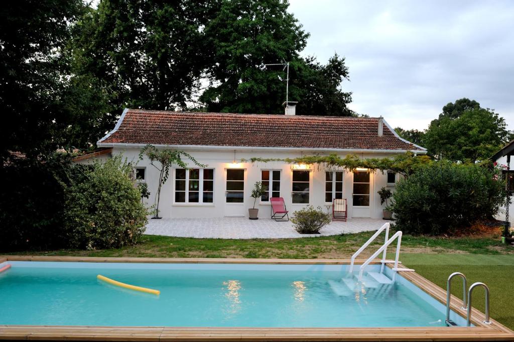 ein Haus mit Pool davor in der Unterkunft La Villa Sainte Catherine in Andernos-les-Bains