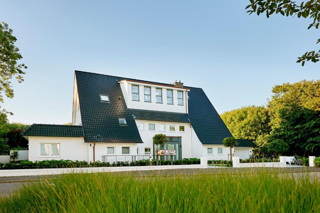 诺德奈Storchennest Norderney的一栋带有黑色屋顶的白色房子