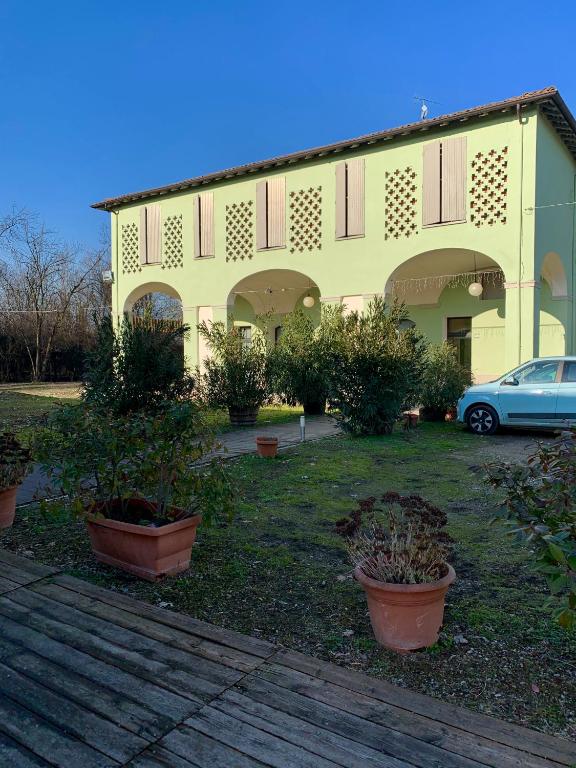 a yellow building with a car parked in a yard at Hotel Riviera Ristorante La Briciola in San Bernardino
