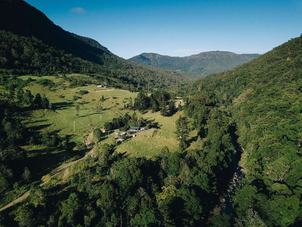 an aerial view of a valley with a house on a mountain at Wongari Eco Retreat in Lamington