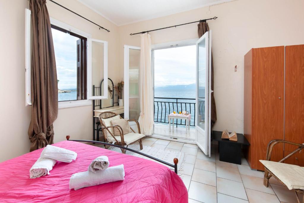 a bedroom with a pink bed and a balcony at Mermaid cottage in Longos