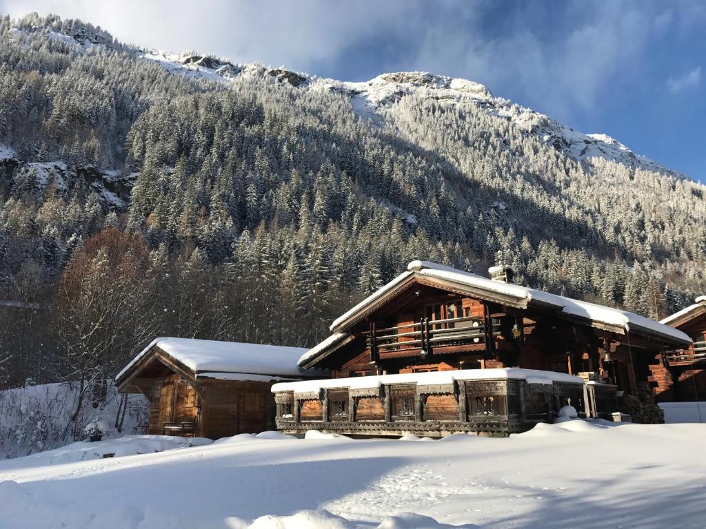 une cabane en rondins dans la neige avec une montagne dans l'établissement CHALET ALBA, à Chamonix-Mont-Blanc