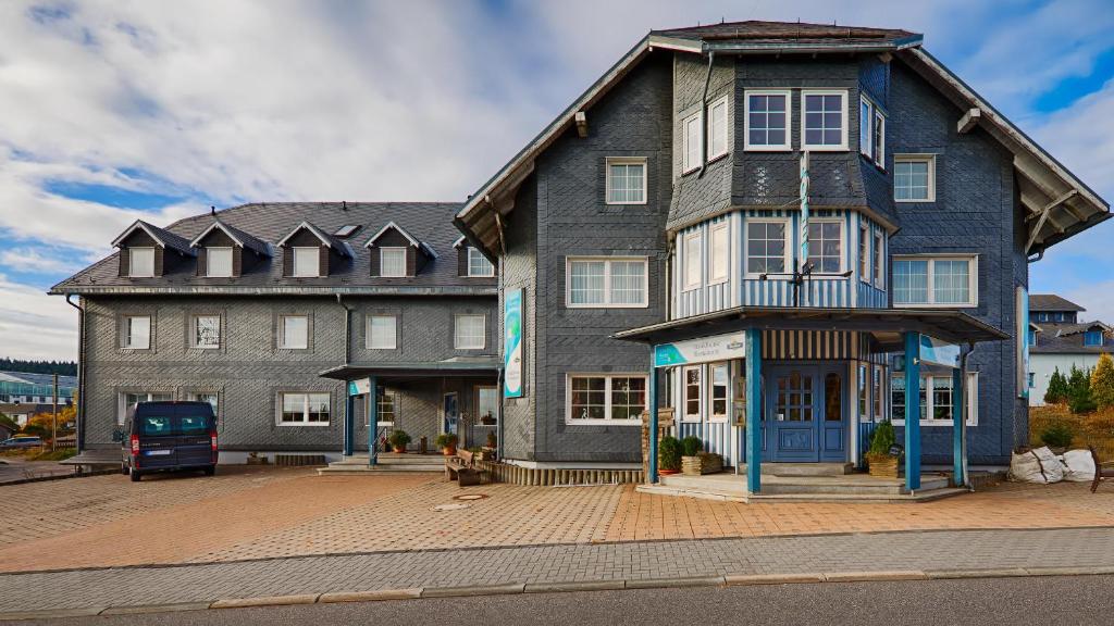 a large house with a car parked in front of it at Hotel Auerhahn in Masserberg