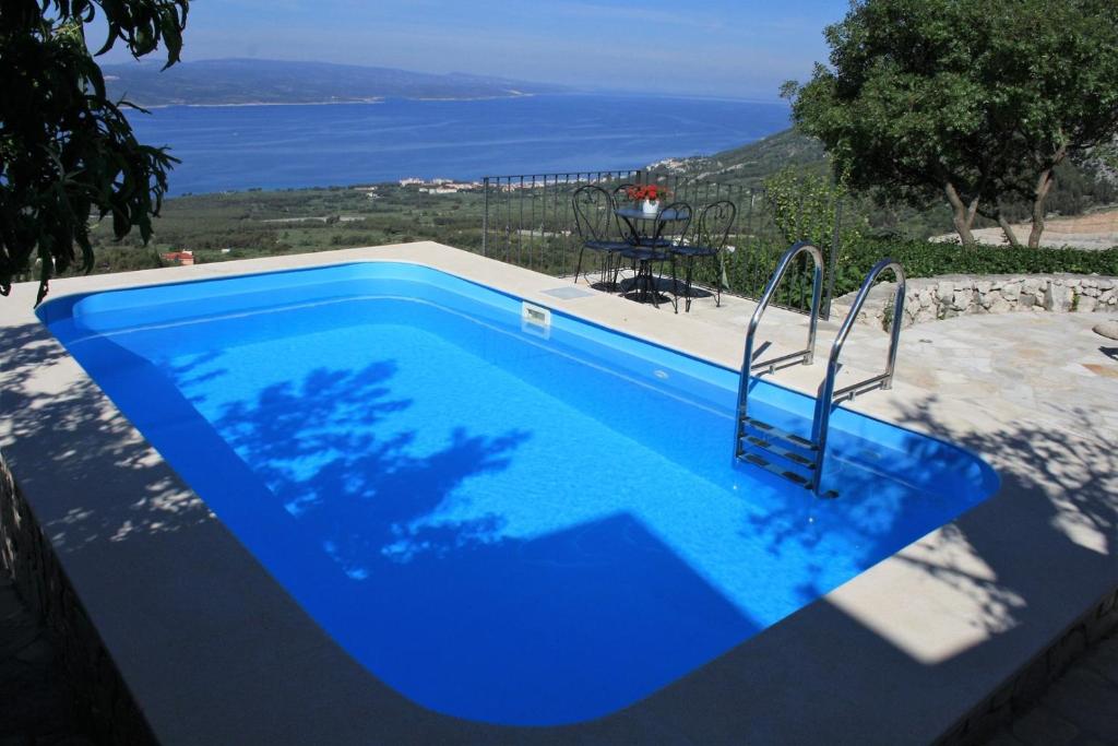 a blue swimming pool with a view of the ocean at Villa Beloved near Baska Voda, private pool in Bast