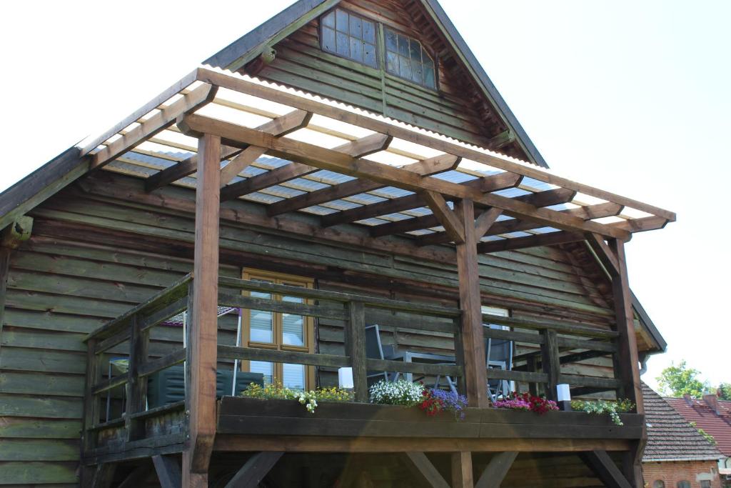 un edificio de madera con pérgola. en Ferienwohnung, en Canow