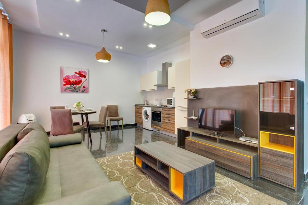 a living room with a couch and a tv at Chalet Apartments in Sliema