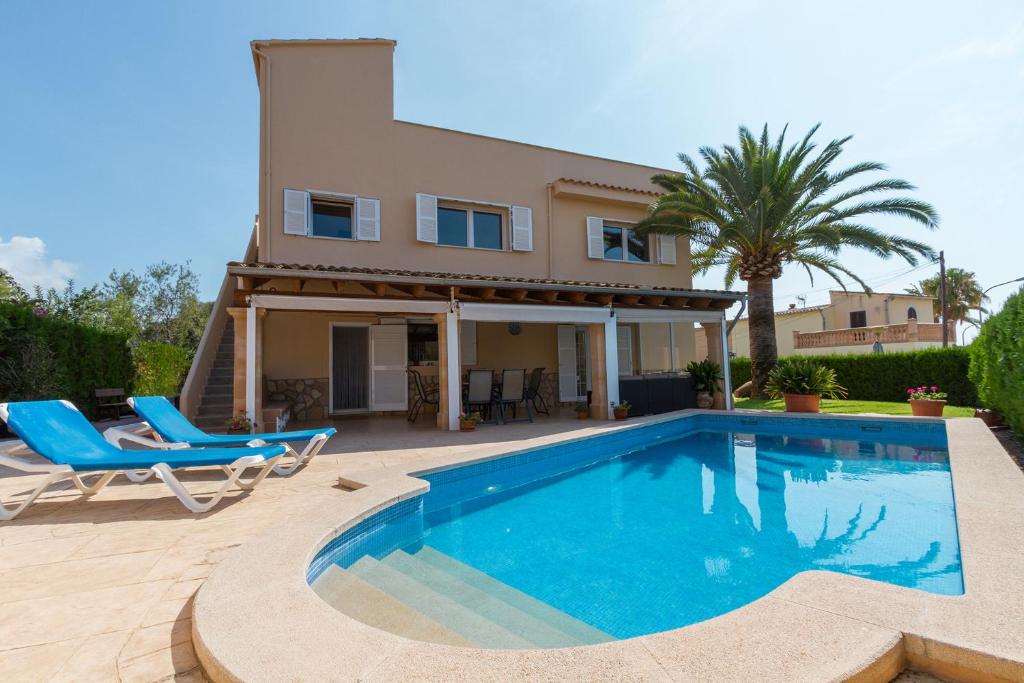 a villa with a swimming pool in front of a house at Villa ALZINA in Cala Millor