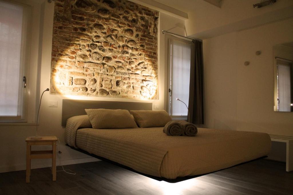 una camera con un grande letto con un muro di mattoni di La Barcaccia a Verona
