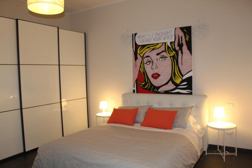 um quarto com uma cama com 2 candeeiros e um quadro em B&b My Bergamo em Bérgamo
