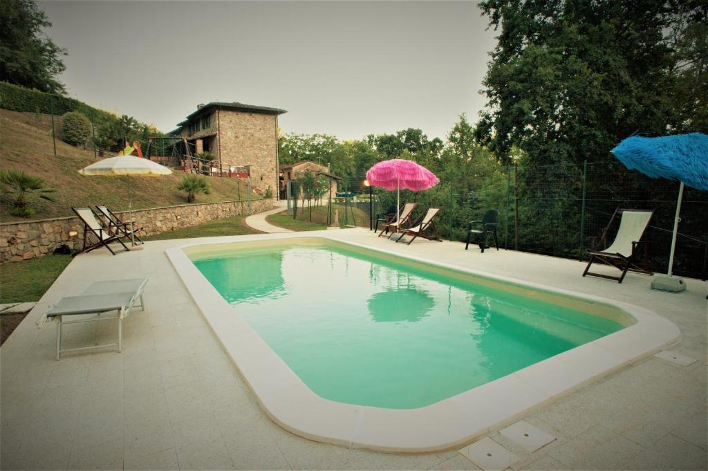 einen Pool mit Stühlen und Sonnenschirmen auf einer Terrasse in der Unterkunft Casa delle Palme in Monsagrati