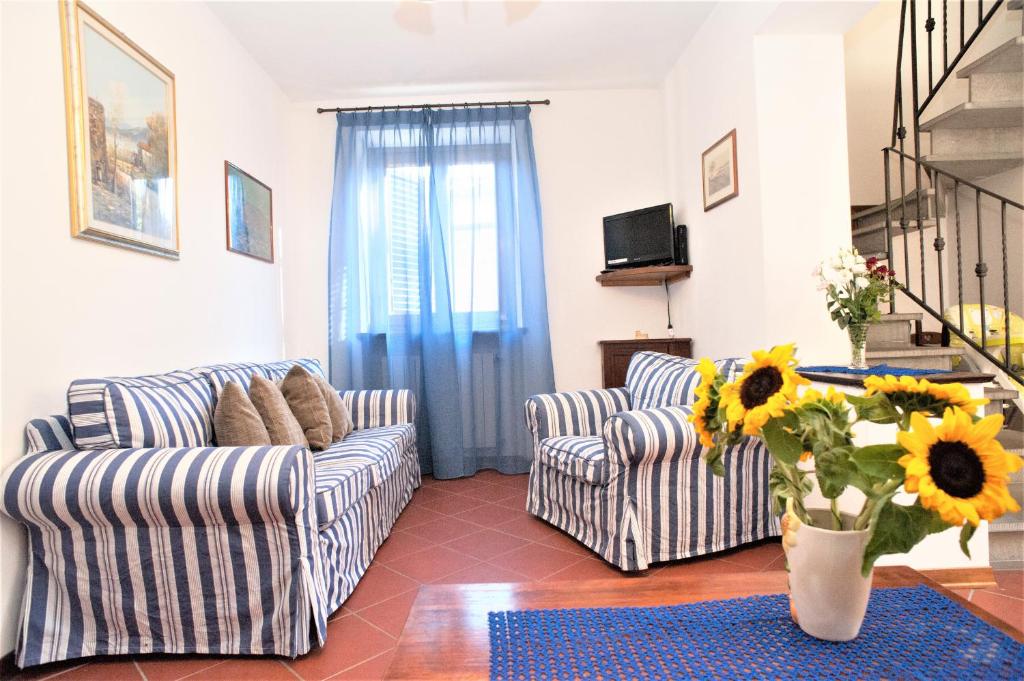 salon z 2 kanapami i wazą kwiatów w obiekcie Casa delle Palme w mieście Monsagrati