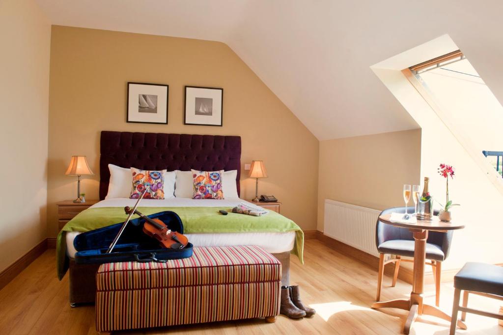 a bedroom with a bed with a violin on a ottoman at Kinvara Guesthouse in Kinvara