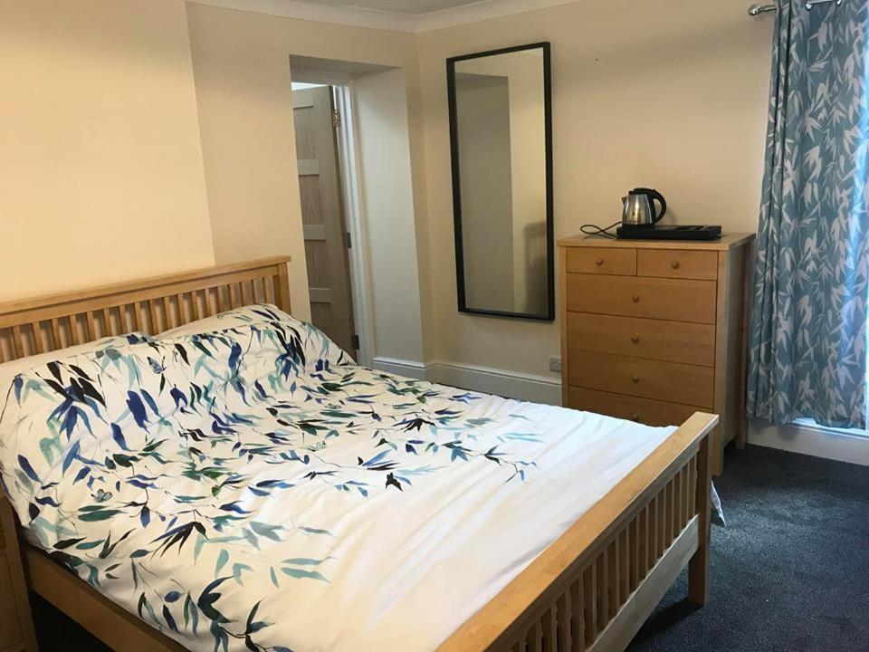 a bedroom with a bed with a dresser and a mirror at White Hart Inn in Cinderford