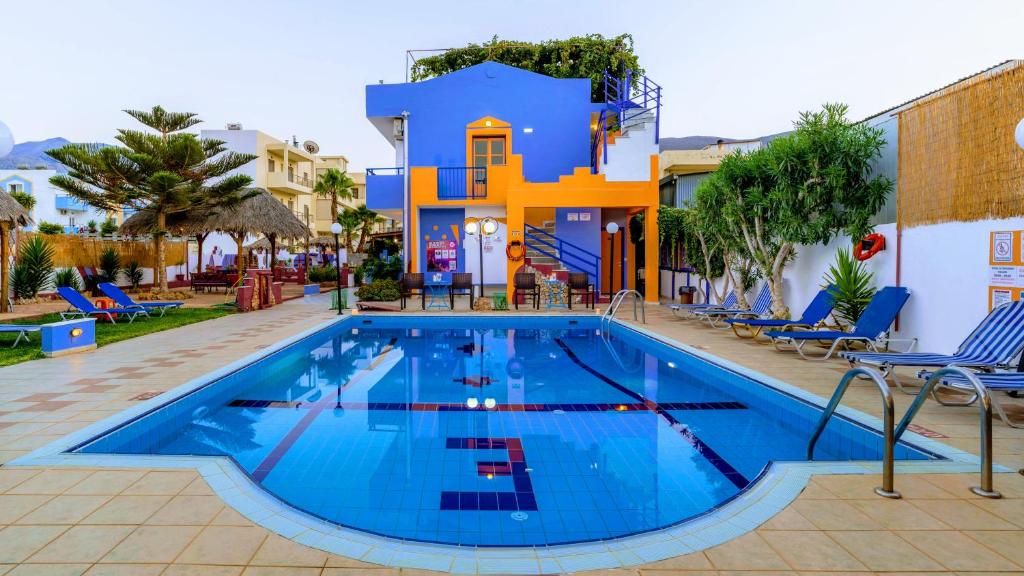 a swimming pool in front of a villa at Eltina Apartments in Malia