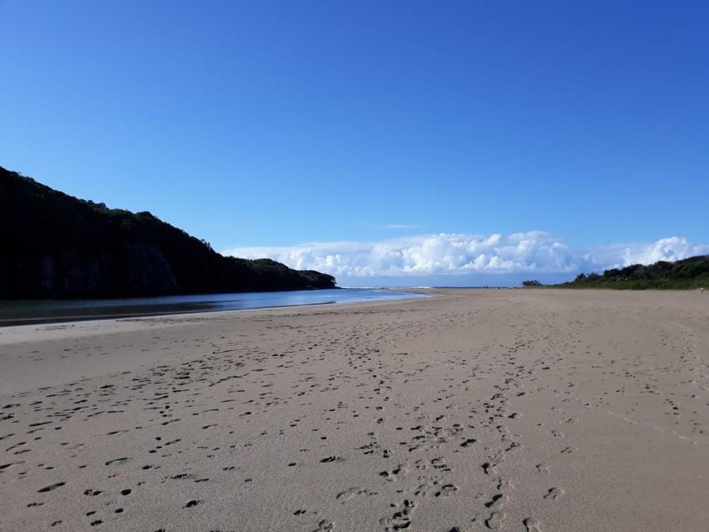 una spiaggia sabbiosa con impronte di piedi sulla sabbia di 9 Coogee Bay a East London