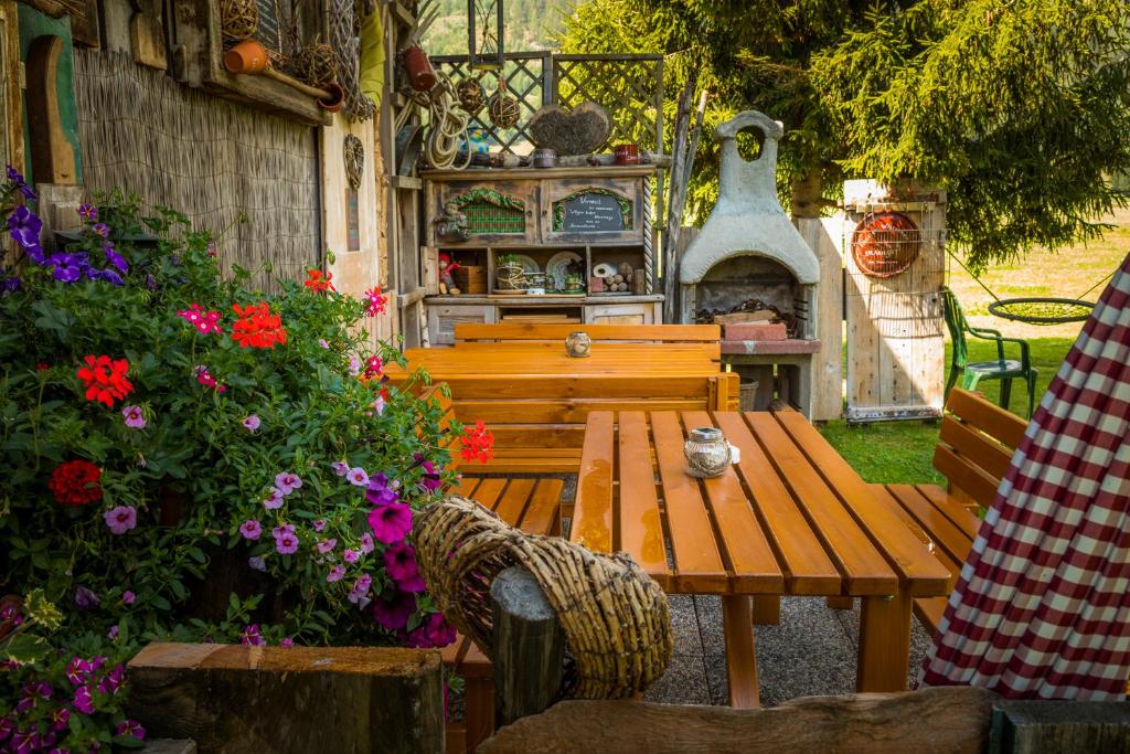 a wooden table and bench in a garden with flowers at Urbangut in Sankt Michael im Lungau