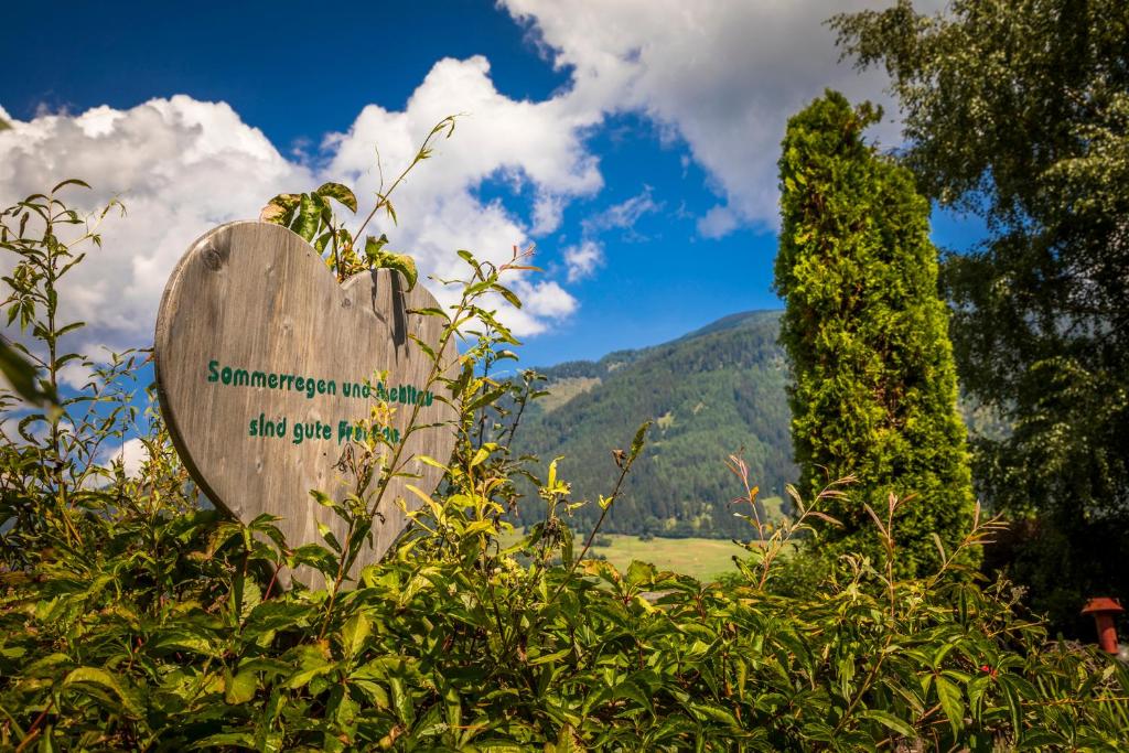 a sign in a bush with a mountain in the background at Urbangut in Sankt Michael im Lungau